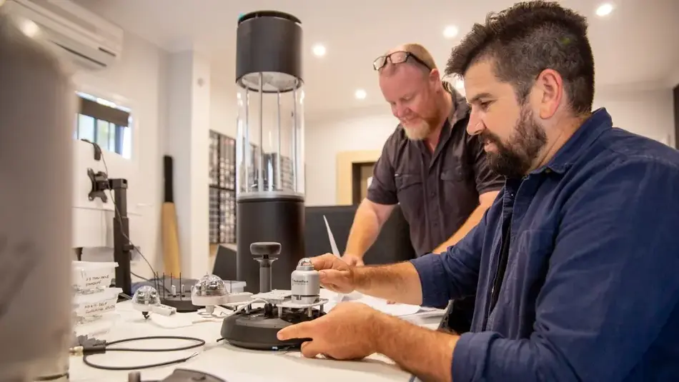 Two people working with technical equipment and instruments in a modern workspace focused on smart city technology.