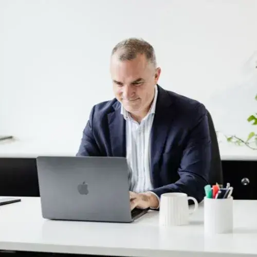 Businessman working on a laptop at a desk in a bright office