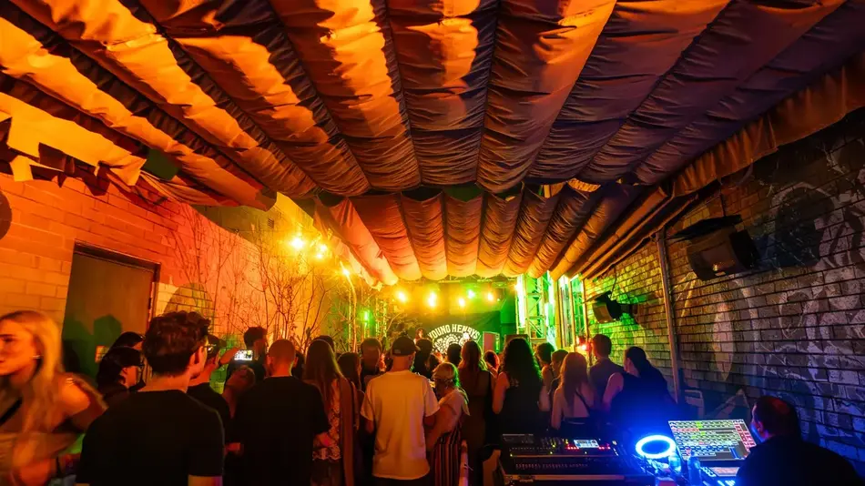 Crowd enjoying live music at West Best Bloc Fest in Newcastle under vibrant lighting and a sweeping fabric ceiling.
