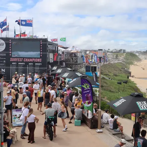 Crowds gathered at Merewether Beach for Surfest surfing competition with event signage and ocean views.