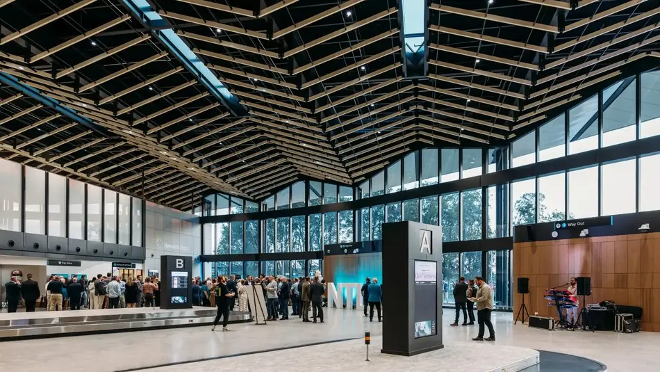 Newcastle Airport's new terminal, with floor to ceiling glass windows, an angular roof and luggage carousels. 